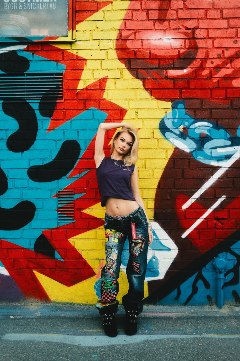 emoemy framför en graffitivägg